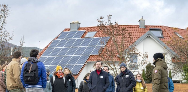 Dachflächen-Photovoltaik mit Menschen die davor stehen