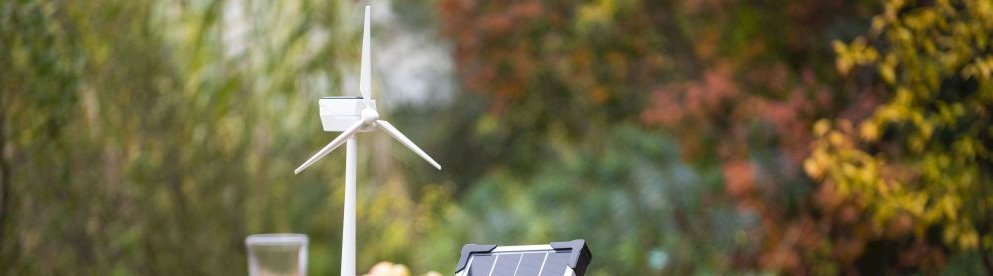 Windenergie Modell und Solar Modul auf Tisch im Garten