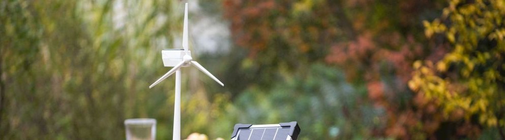 Windenergie Modell und Solar Modul auf Tisch im Garten