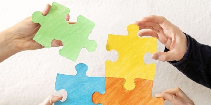 © Energieagentur Rheinland-Pfalz Hände halten vier verschieden farbende Puzzelteile zusammen